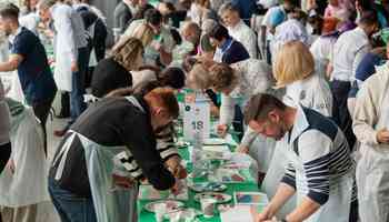 Colleagues from different departments taking part in a team building Big Picture challenge in an indoor setting