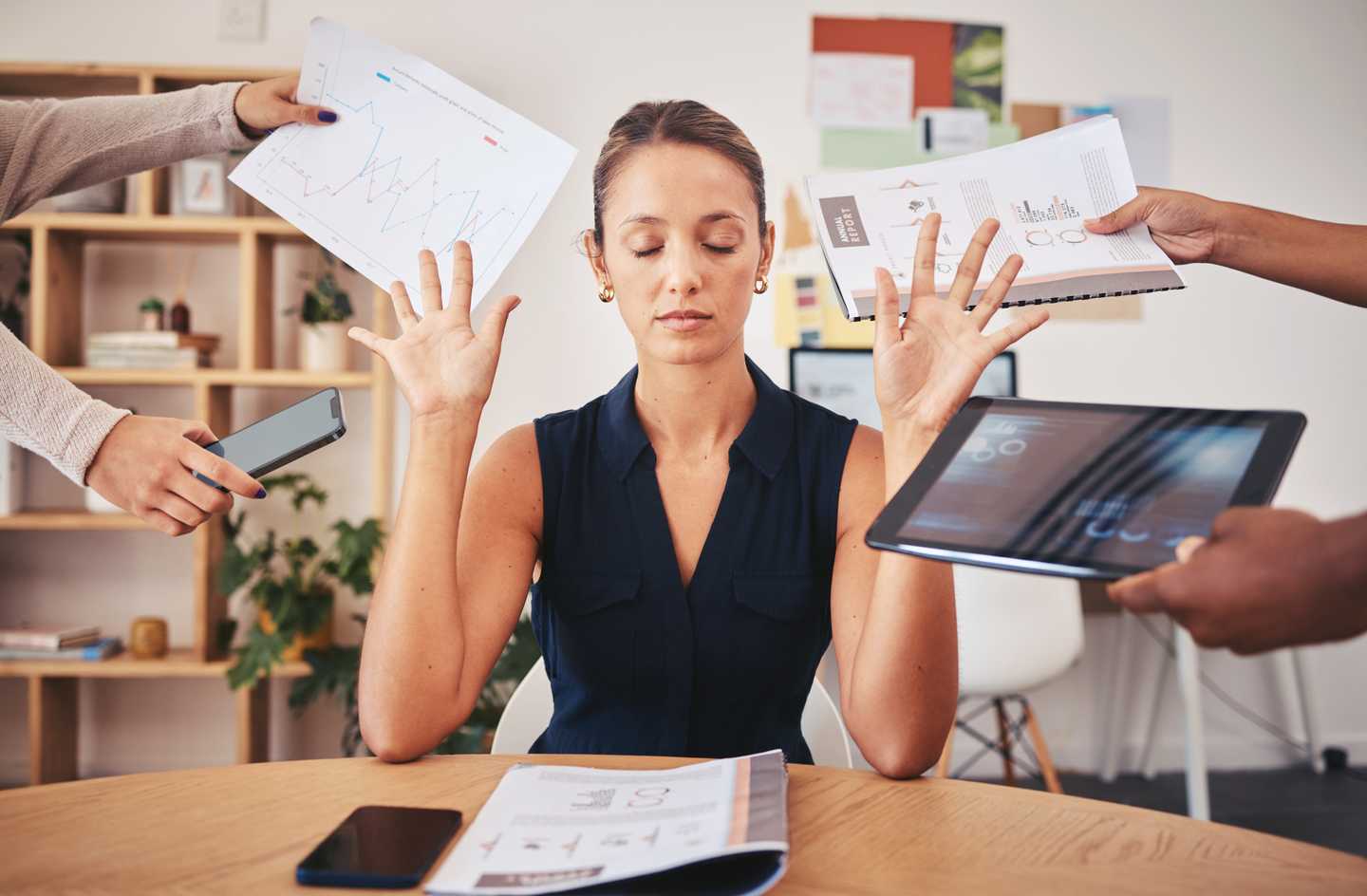 Stressed office worker closing eyes while colleagues demand attention with charts devices and reports representing quiet cracking and employee disengagement at work